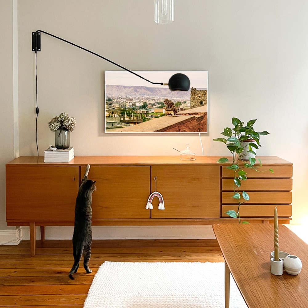 Infrarotheizung mit Urlaubsbild hängt im Wohnzimmer